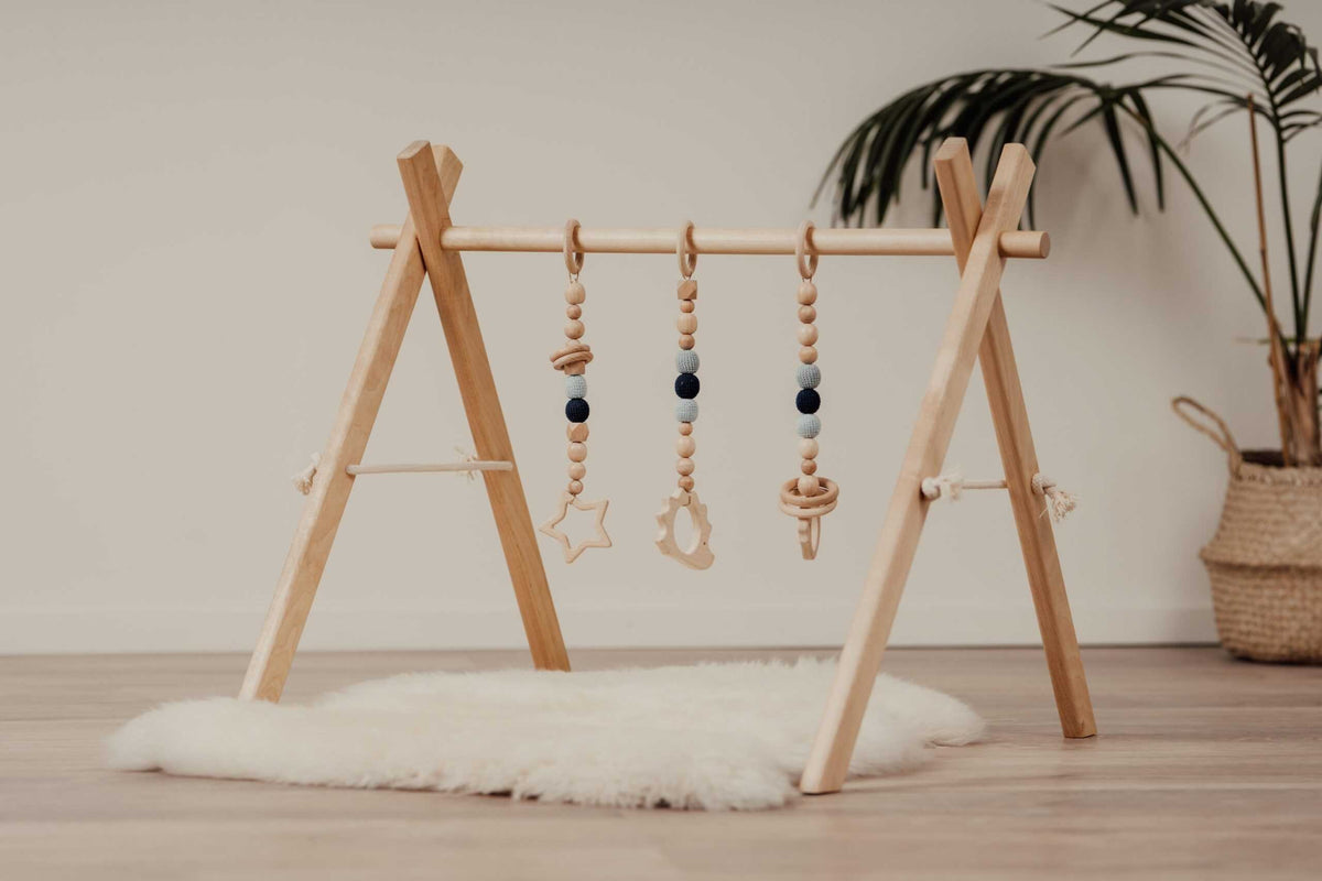 Babygym i trä med blå hängande leksaker från leg&go