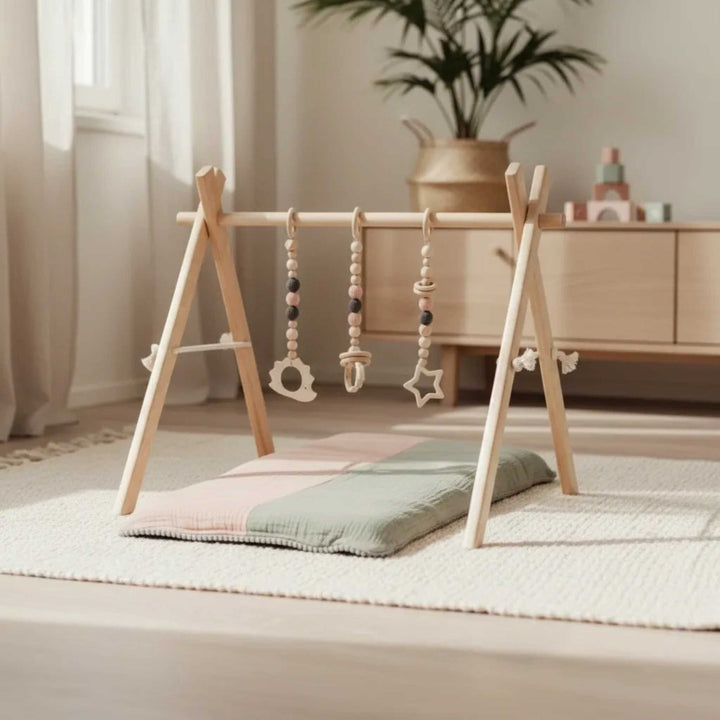 Babygym i trä med rosa hängande leksaker från leg&go