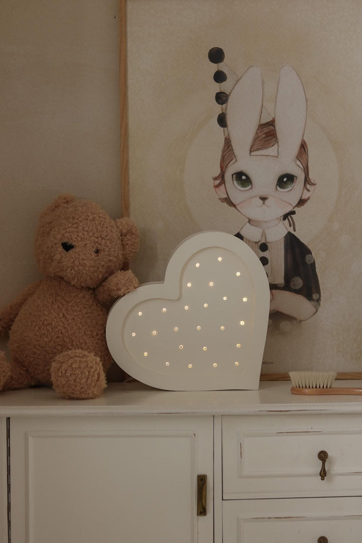Tänd vit Little Lights hjärtformad nattlampa i trä på möbel